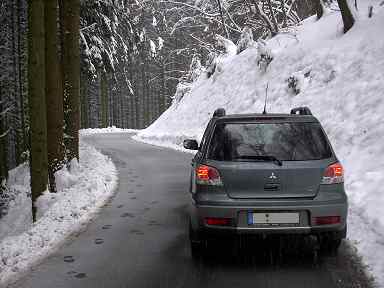 Der Outlander auf einem verschneiten Bergweg - Ansicht von hinten. 